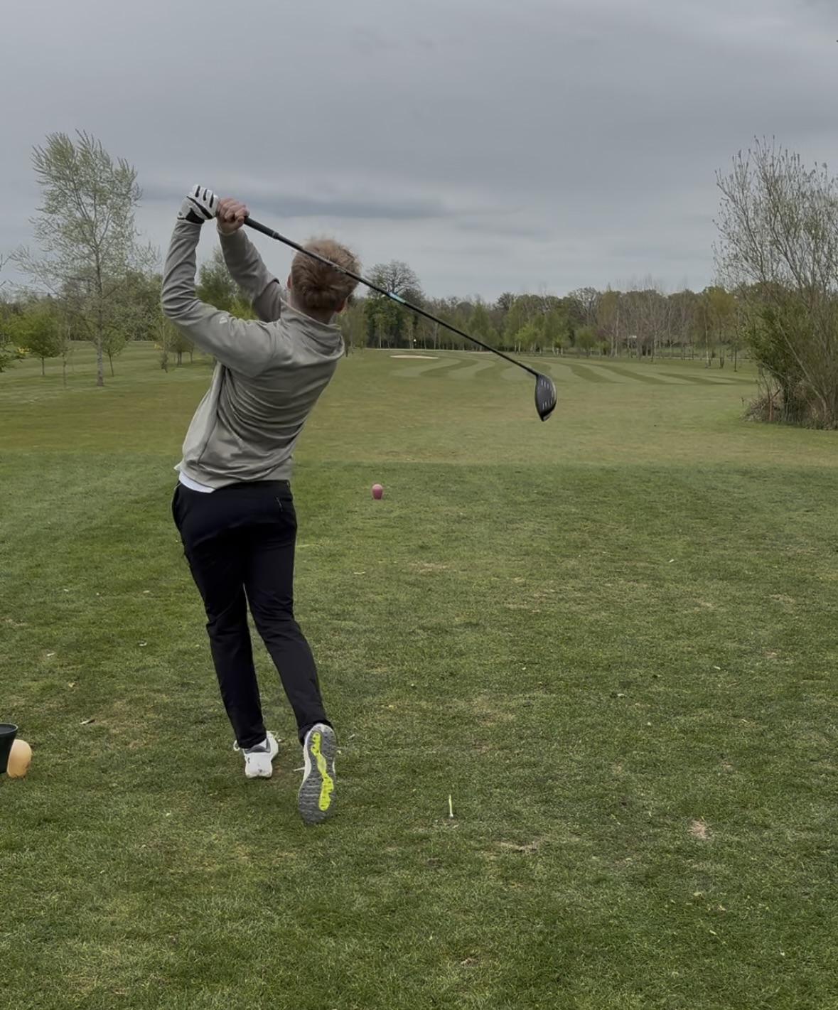 Thomas Boyd mid-swing on a golf course tee