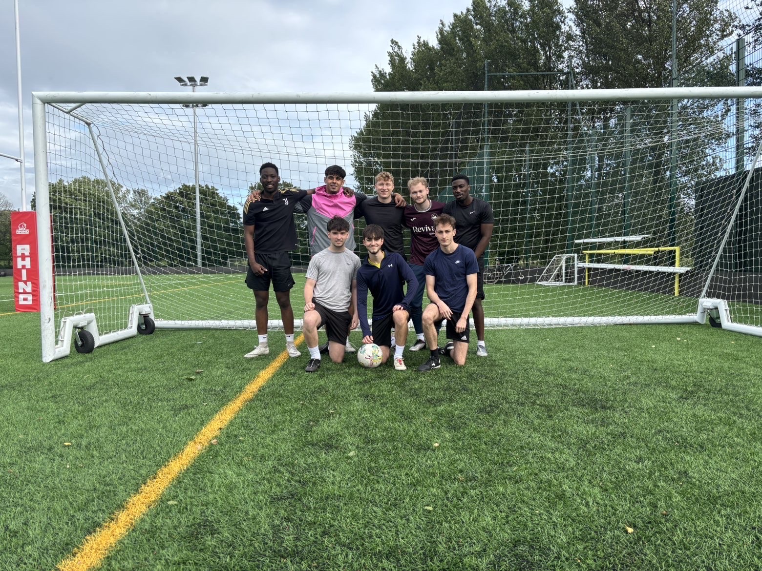 University seven-a-side football team posing in front of a goal